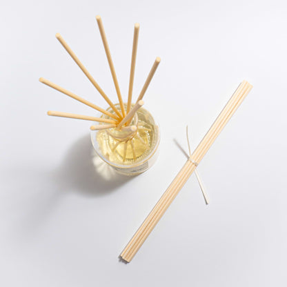 set of 10 replacement reed diffuser sticks available for purchase made from natural fibres, natural colour, pictured alongside one of our reed diffusers