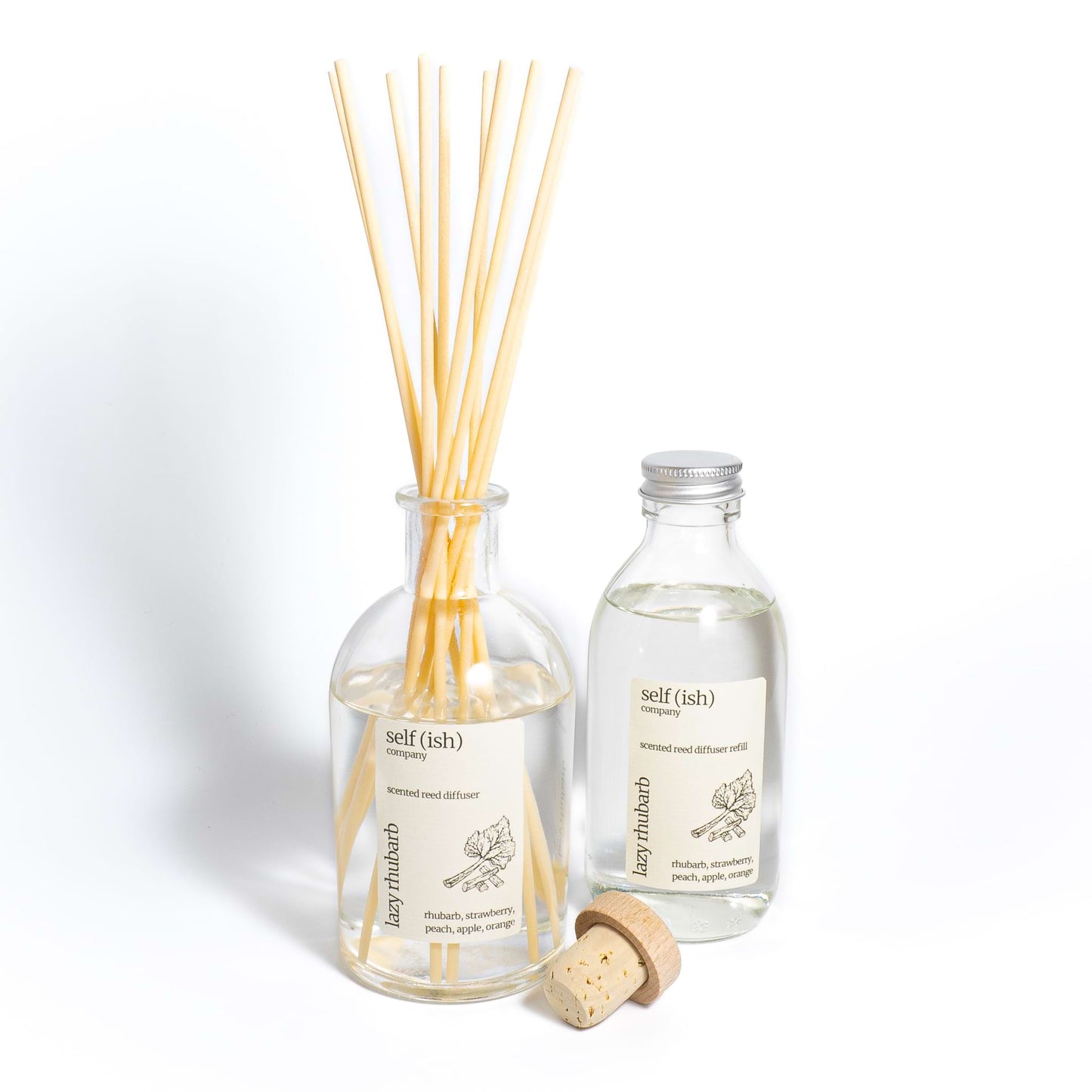 Rhubarb diffuser refill bottle next to rhubarb reed diffuser