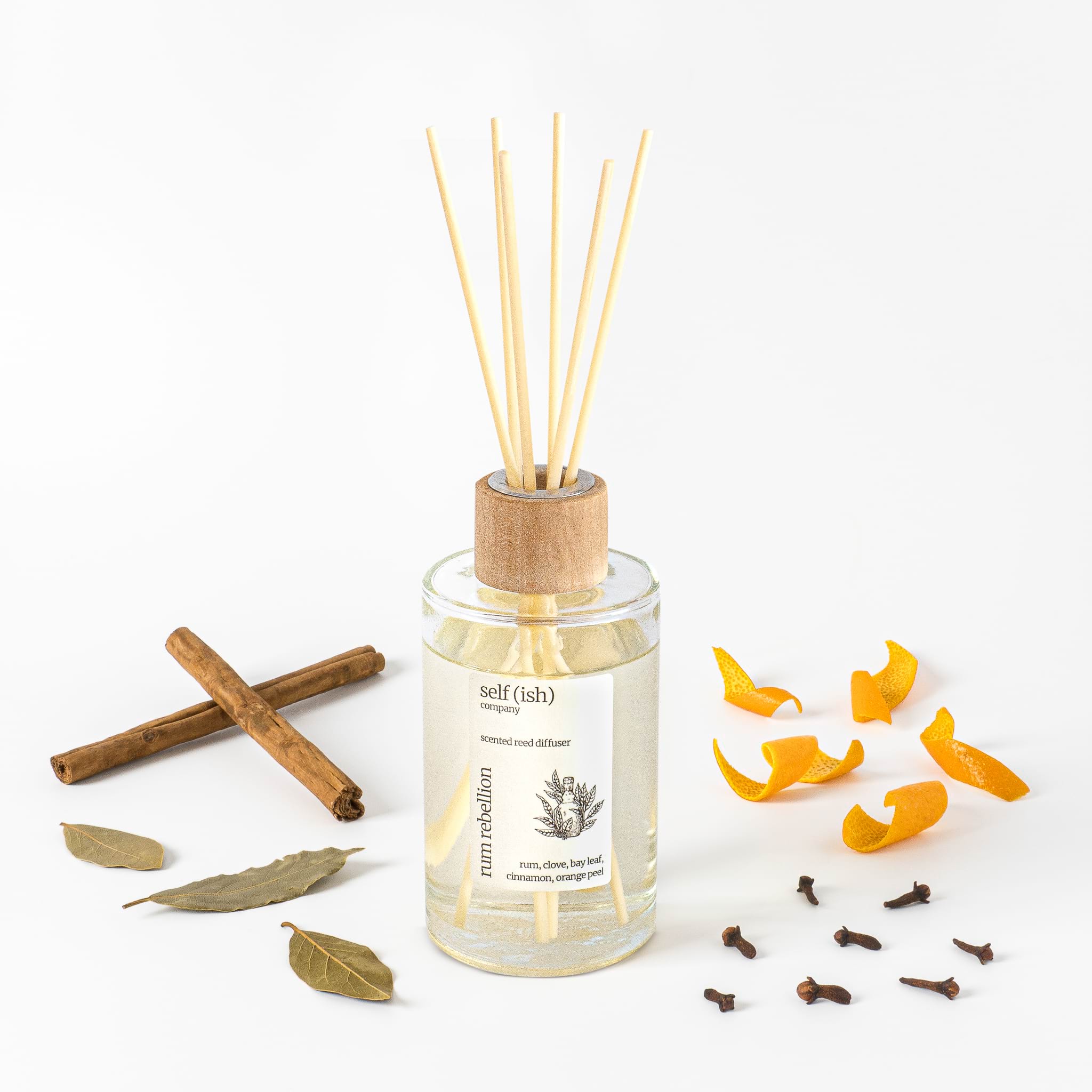 rum reed diffuser with cinnamon, bay leaf, orange peel and clove with white background