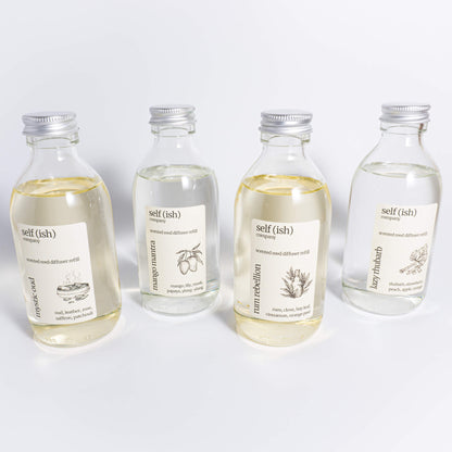 various scented reed diffuser refills available to purchase in clear glass bottles, available in oud, mango, rum and rhubarb scents
